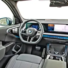 Wnętrze nowoczesnego x3 bmw z dużym ekranem nawigacji i cyfrowymi zegarami.
