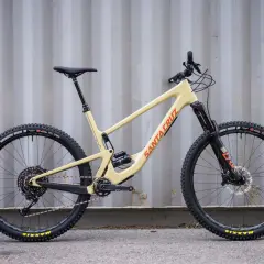 A tan 2020 Santa Cruz Hightower mountain bike with black wheels and orange "Santa Cruz" lettering.