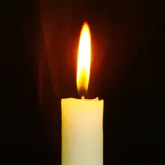 Jasny płomień świecy, niczym nieuchwytna dusza, tańczy w ciemności, rzucając ciepłe światło.