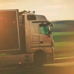 Ciężarówka w ruchu, symbolizująca profesjonalizm i sprawność w transporcie, gdzie kluczowe jest użyczenie certyfikatu kompetencji zawodowych.