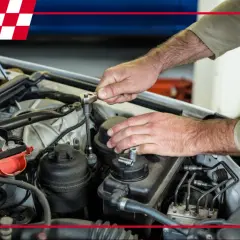 Mechanik dokonuje czyszczenia nagaru w silniku, używając klucza nasadowego.