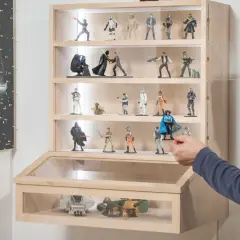 Mann arrangiert Star Wars Figuren in einer selbstgebauten Acryl Vitrine.