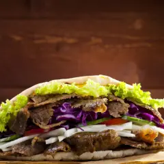 Kebab z mięsem, sałatą, czerwoną kapustą i warzywami w picie.