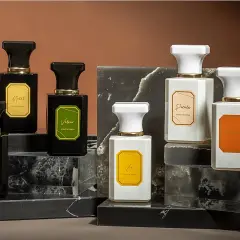Elegantes frascos de perfume, algunos negros y otros blancos, con etiquetas doradas. Podrían ser la mejor colonia Mercadona hombre.