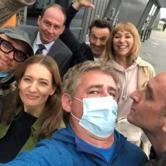 Uśmiechnięta usta usta obsada na planie zdjęciowym. Wszyscy w dobrych humorach, gotowi do pracy.