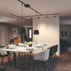 Nowoczesny salon z jadalnią, gdzie centralnym punktem jest stół z krzesłami, a nad nim elegancki system oświetlenia szynowego.