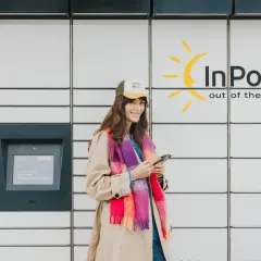 Kobieta z telefonem przy paczkomacie InPost. Czy trzeba drukować etykietę? Nie, wystarczy kod z aplikacji.