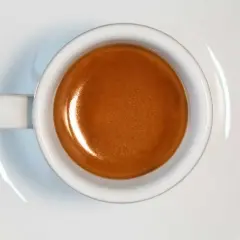 Tazzina di caffè espresso con crema dorata, risultato di un'accurata lavorazione del caffè.