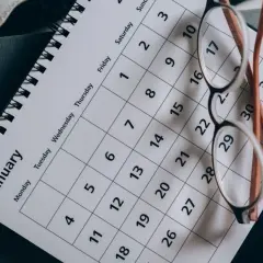Okulary na kalendarzu z napisem "January". Planowanie ważnych terminów, np. Kindergeld termine, wymaga organizacji.