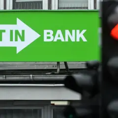 Zielony baner z napisem "GET IN BANK" i strzałką. Zastanawiasz się, co z lokatami w Getin Banku?