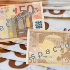 Banknoty 50 euro, oznaczone jako "specimen", leżą na stosie innych banknotów.