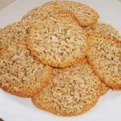 En hög med krispiga, gyllene glutenfria havreflarn på en vit tallrik. Perfekta för fikat!