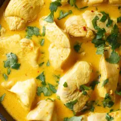 Ein klassisches Curry-Hähnchen-Rezept in cremiger Sauce, garniert mit frischer Petersilie.