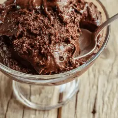 Une coupe de verre remplie de mousse au chocolat maison, prête à être dégustée. La texture est riche et onctueuse, parfaite pour la conservation.