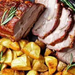 Fettine di maiale al forno morbide, succulente e dorate, servite con patate arrosto e rosmarino fresco.