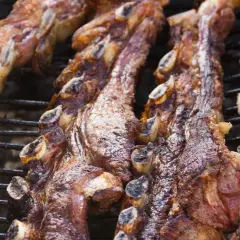 Costillas de churrasco al horno, doradas y jugosas, listas para disfrutar en una parrilla.