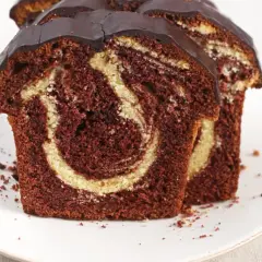 Zwei saftige Scheiben Marmorkuchen mit Schokoladenglasur, perfekt für ein schnelles Marmorkuchen Rezept.