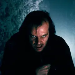 Przerażająca twarz Jacka Torrance'a, ikona **stare horrory**, wyłania się z mroku.