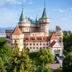 Majestatyczny zamek Bojnice, jeden z najpiękniejszych zamków na Słowacji, otoczony zielenią.