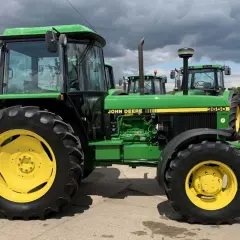 Zielony traktor John Deere 3650 z żółtymi felgami, gotowy do pracy na polu.