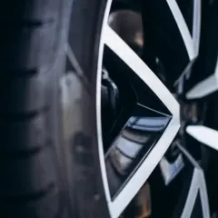 Zbliżenie na felgę z ostrymi, geometrycznymi ramionami. Widać jej szerokość i nowoczesny design.