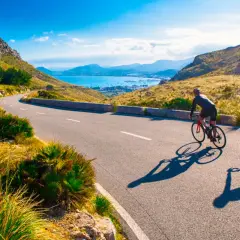 Två cyklister njuter av en solig dag med att cykla på Mallorca, med en fantastisk utsikt över havet och bergen.