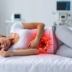 Kobieta cierpi na bóle brzucha, symbolizujące wirusową biegunkę. Zastanawia się, ile trwa biegunka wirusowa u dorosłych.