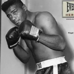 Floyd Patterson, a legendary boxer, poses in the ring, his record etched in boxing history.
