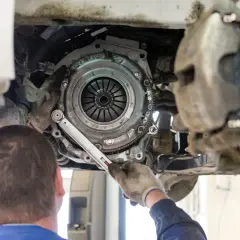Mechanik dokręca śruby nowego sprzęgła. Czas pracy, ile trwa wymiana sprzęgła, zależy od modelu auta i doświadczenia.