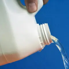 Un bidon blanc verse un liquide transparent. C'est de l'eau oxygénée, idéale pour le linge couleur.