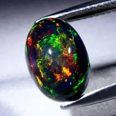 Ein faszinierender schwarzer Opal mit lebendigen Farbspielen von Grün, Rot und Gelb. Seine Wirkung ist magisch.