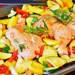 Gotowe do pieczenia: pieczone udka z kurczaka z ziemniakami, cukinią, papryką i ziołami.