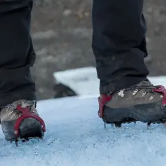 Czarne spodnie i buty z rakami w podeszwie, gotowe na lodową przygodę.