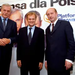 Trzech mężczyzn w garniturach, założyciele Platformy Obywatelskiej, pozuje na tle banera z napisem "Szansa dla Polski".