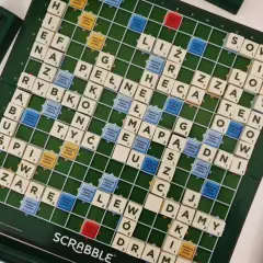 Plansza do gry Scrabble z ułożonymi słowami, pokazująca zasady gry i pola premiowe.