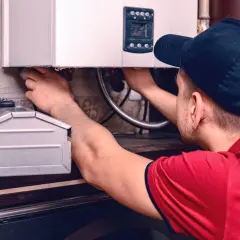 Instalator przy kotle gazowym, który pomoże Ci dowiedzieć się, jak zakręcić wodę w kaloryferze.