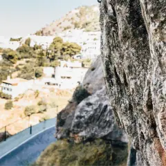 Roca en primer plano con vistas a un pueblo blanco en la sierra de Gador.