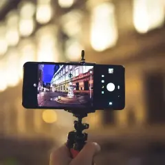 Smartfon na statywie, uchwycił nocną ulicę z fontanną. Dowiedz się, jak ustawić aparat w telefonie, by uzyskać takie ujęcia.
