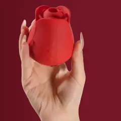 Czerwony wibrator z silikonu medycznego w kształcie róży, trzymany w dłoni.