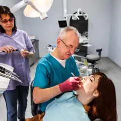 Dentista esamina una paziente. L'alitosi quando preoccuparsi? Chiedi al tuo dentista.