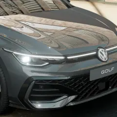 Parte anteriore di una Volkswagen Golf 7 diesel grigia, con fari a LED accesi e il logo VW al centro.