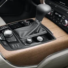 Eleganckie drewniane wykończenie konsoli środkowej Audi z dźwignią skrzyni biegów multitronic i przyciskiem Start/Stop.