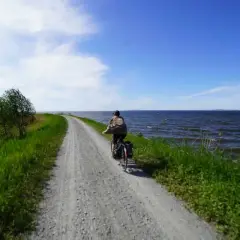 Rowerzysta przemierza malownicze trasy rowerowe Szczecin wzdłuż jeziora.