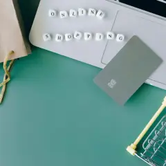 Karty płatnicze, torba i mini wózek na zakupy na laptopie symbolizują wygodne **alsendo** zakupy online.