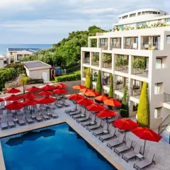 TUI Suneo Tsilivi Admiral: basen z leżakami i parasolami, nowoczesny hotel, morze w tle.
