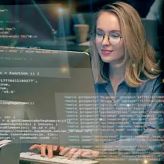 Frau lernt Programmieren im Fernstudium. Sie arbeitet konzentriert an ihrem Computer, um Fachinformatiker zu werden.