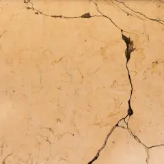 Surface de céramique beige fissurée, montrant comment réparer une céramique cassée.