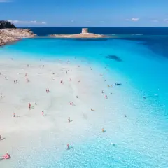 Piękna plaża na Sardynii, idealna na wakacje. Kiedy lecieć na Sardynię? Latem, by cieszyć się słońcem i turkusową wodą.