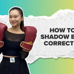 A young woman in boxing gloves smiles, ready to teach you how to shadow box correctly.