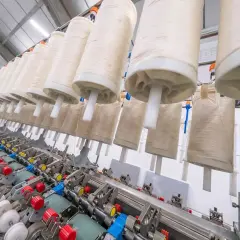Machine à filer le lin en France, avec de grands rouleaux de fil prêts à être transformés.